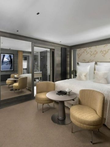 Geräumiges Doppelzimmer mit goldenen Sesseln und zeitgemäßem Design.