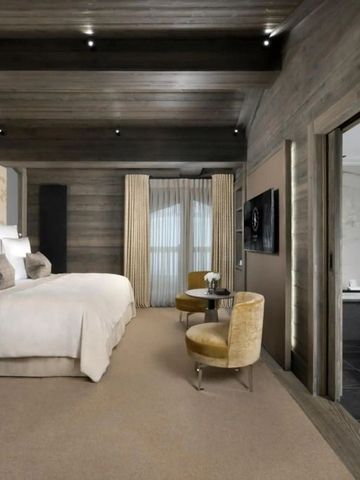 Moderne Hotelsuite mit separatem Badbereich und warmen Holztönen.