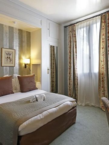 Klassisch eingerichtetes Hotelzimmer mit floralen Vorhängen und Doppelbett.