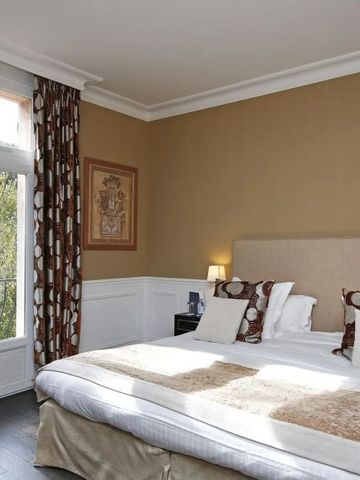 Geräumiges Doppelzimmer mit großen Fenstern und dezenter Beleuchtung.