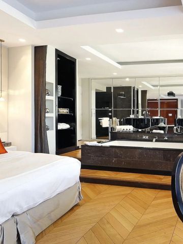 Luxuriöse Suite mit modernem Bad und dekorativen Elementen.