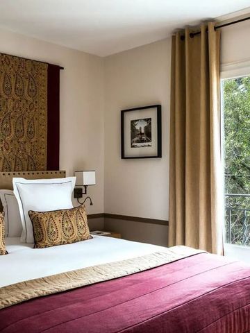 Elegantes Hotelzimmer mit Doppelbett, kunstvolles Design und Blick auf den Garten