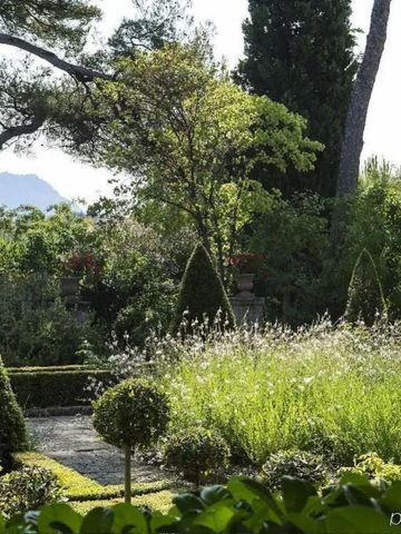 Eleganter Garten mit üppiger Vegetation und Blick auf die Berge im Hintergrund