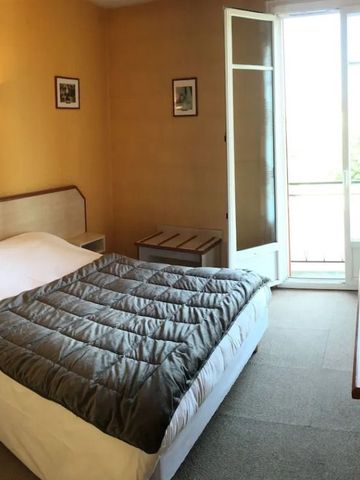 Hotelzimmer mit Doppelbett und Zugang zu einem kleinen Balkon.