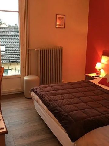 Gemütliches Hotelzimmer mit Doppelbett und warmen Farbtönen.