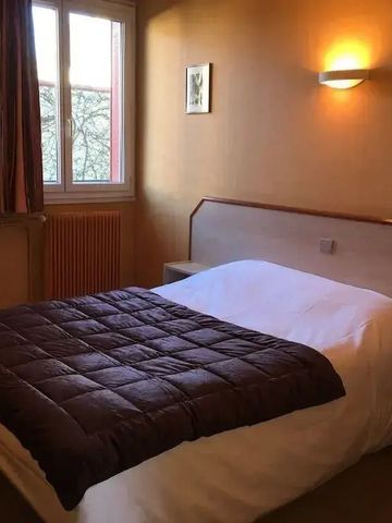 Hotelzimmer mit Doppelbett und natürlichem Licht durch Fenster.