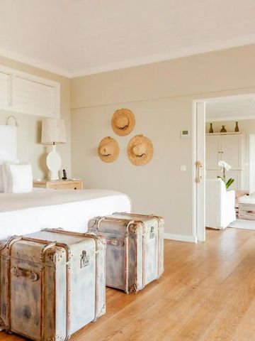 Elegantes Schlafzimmer mit Holzfußboden und Dekorationen