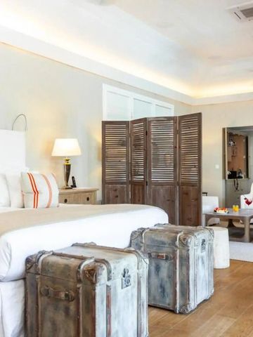 Großzügige Suite mit Bett und Sitzbereich in hellen Farben