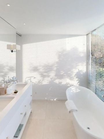 Modernes Badezimmer mit freistehender Badewanne und großer Glasfront