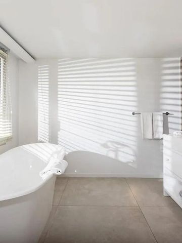 Helles Badezimmer mit freistehender Wanne und schickem Design