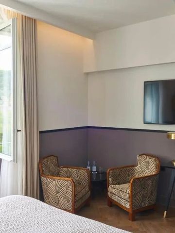 Gemütliches Hotelzimmer mit zwei Sesseln und offenem Fenster