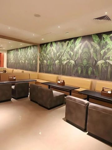 Gemütlicher Lounge-Bereich mit grüner Pflanzenwand und komfortablen Sitzgelegenheiten