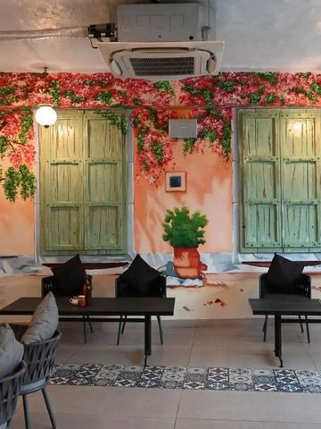 Stilvoller Raum mit Wandgemälde aus Blumen und Fensterattrappen über Sitzplätzen