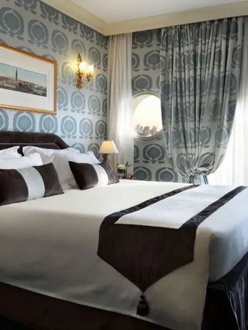 Elegantes Hotelzimmer mit Doppelbett und stilvoller Tapete, Blick auf Venedig.