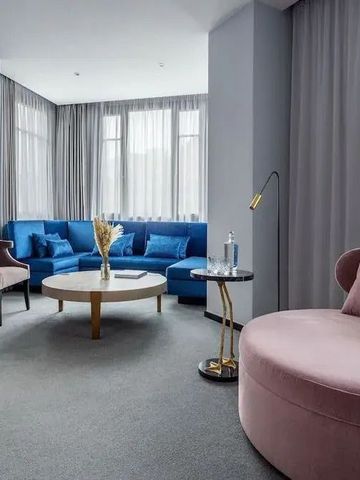 Eleganter Wohnbereich mit blauen Sofas und großen Fenstern
