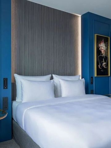 Elegantes Hotelzimmer mit großem Bett und stilvoller Wanddekoration