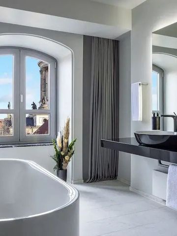 Geräumiges Badezimmer mit freistehender Badewanne und Ausblick auf die Stadt