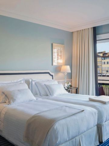 Zimmer mit Doppelbett und Blick auf den Fluss