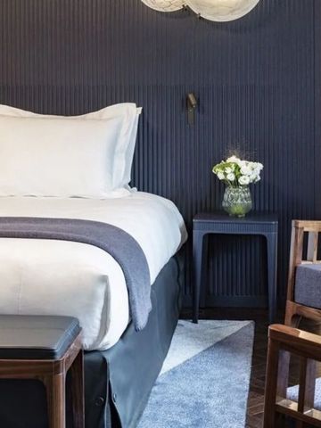 Hotelzimmer mit eleganter Farbgebung und komfortablem Bett