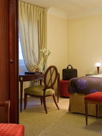 Elegantes Hotelzimmer mit Schreibtisch und stilvollen Möbeln.