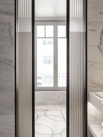 Modernes Badezimmer mit Marmorwänden und stilvollem Waschbecken.