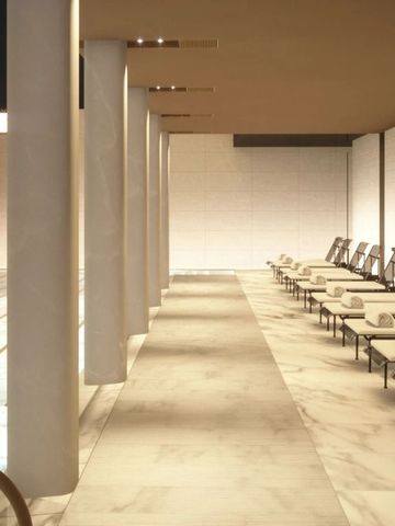 Eleganter Poolbereich mit Liegen und Marmorboden