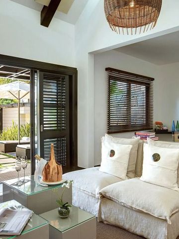 Gemütliche Wohnzimmereinrichtung mit Zugang zum Garten im LUX* Belle Mare Hotel auf Mauritius