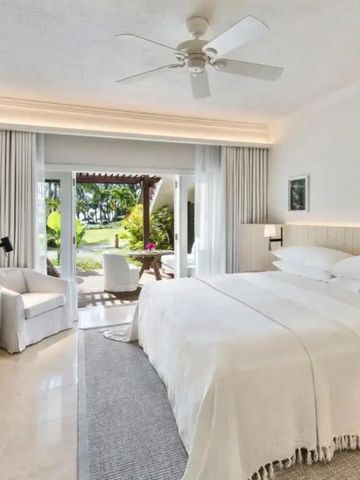 Helles Hotelzimmer mit Zugang zur Terrasse und Gartenblick