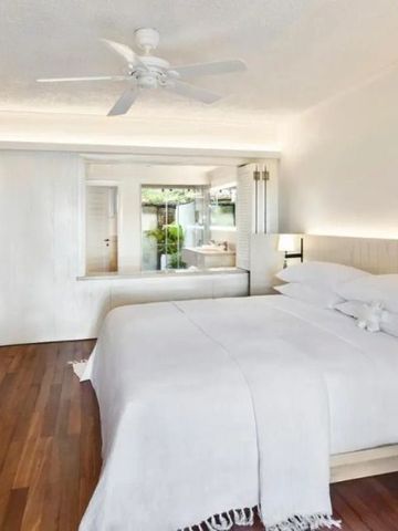 Helles Hotelzimmer im LUX* Le Morne mit großem Bett und Holzfußboden