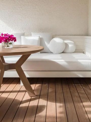 Gemütliche Terrasse mit weißem Sofa und Blumen im LUX* Le Morne