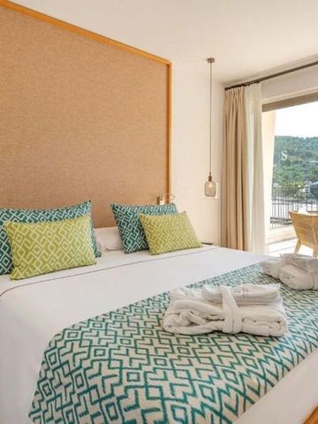 Doppelzimmer mit großen Fenstern und Blick auf eine Terrasse mit Sitzbereich.