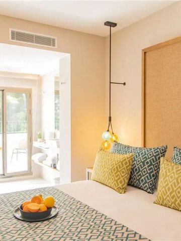 Einladendes Zimmer mit modernem Dekor und Zugang zu einem Balkon.