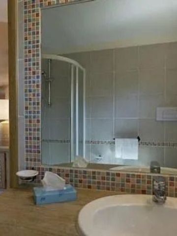 Geräumiges Badezimmer mit moderner Dusche und stilvollem Spiegel im Hotelzimmer