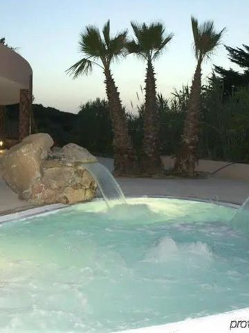 Außen-Whirlpool im Hotelgarten mit Wasserfällen und umgebenden Palmen