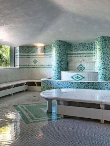 Mosaik-Dampfbad mit grünen und weißen Mustern und großzügiger Sitzfläche