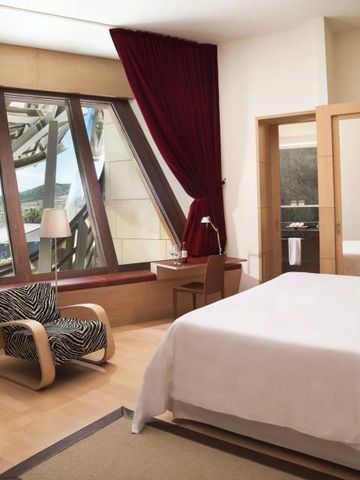 Elegantes Hotelzimmer mit Panoramafenster und rotem Vorhang