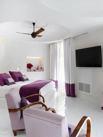 Luxuriöses Zimmer mit lila Akzenten und großem Flachbildfernseher