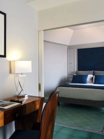 Elegantes Hotelzimmer mit Schreibtisch und Kunstwerk an der Wand