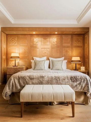 Gemütliches Schlafzimmer mit edler Holzwand und feiner Bettwäsche