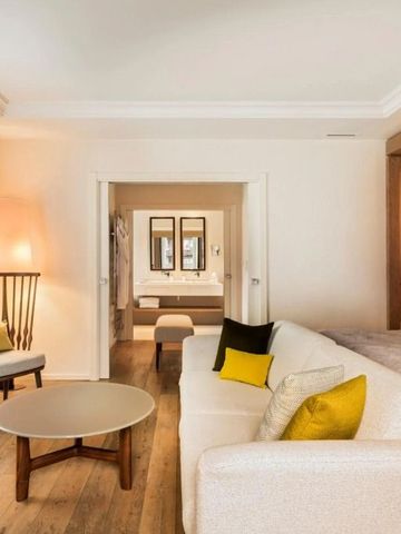 Geräumige Suite mit modernem Wohnbereich und Blick ins Badezimmer