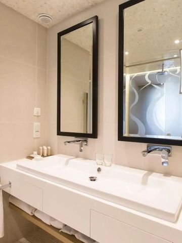 Modernes Badezimmer mit Doppelwaschbecken und großem Spiegel