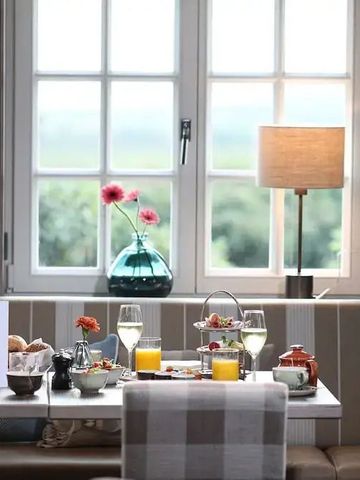 Gemütliche Sitzecke im Restaurant mit großem Fenster und Tischdekoration.