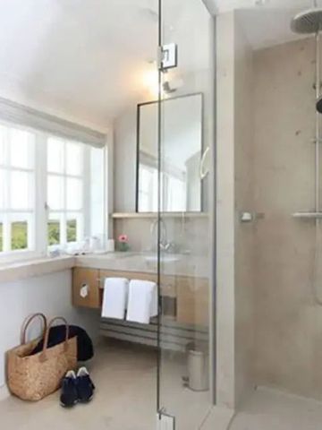 Modernes Badezimmer mit Dusche und großen Fenstern.