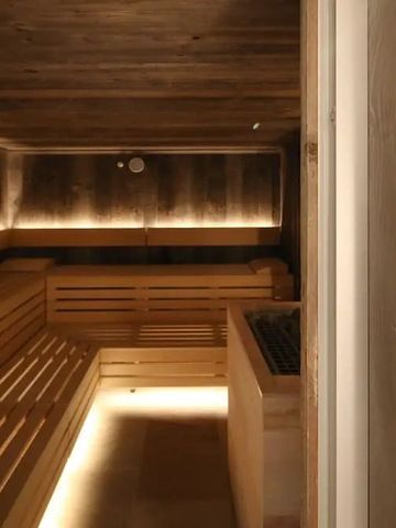 Warme und gemütliche Sauna mit Holzbänken und gedämpftem Licht