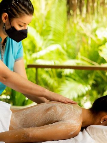 Frau genießt entspannende Massage in tropischer Umgebung