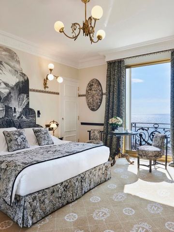 Heller Hotelraum mit kunstvollem Wandbild und Meerblick vom Balkon