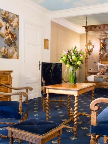 Klassisches Hotelzimmer mit reich verzierten Möbeln und blauen Akzenten