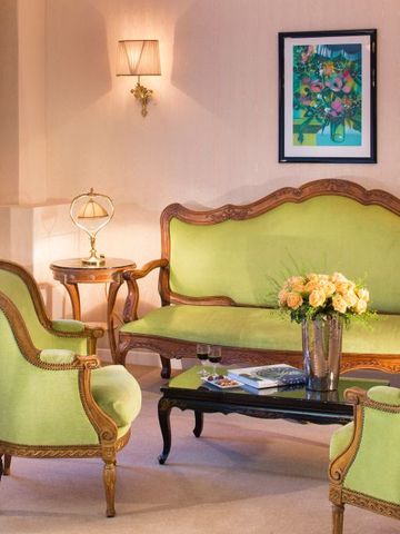 Elegantes Wohnzimmer mit klassischen grünen Sesseln und einem Sofa.