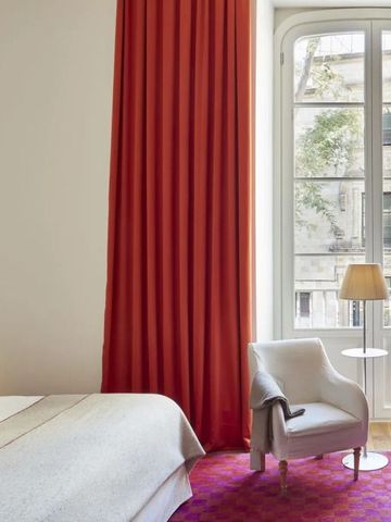 Geschmackvoll dekoriertes Zimmer mit roten Vorhängen und Sitzbereich