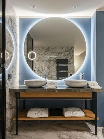 Modernes Badezimmer mit Doppelwaschbecken und großen runden Spiegeln